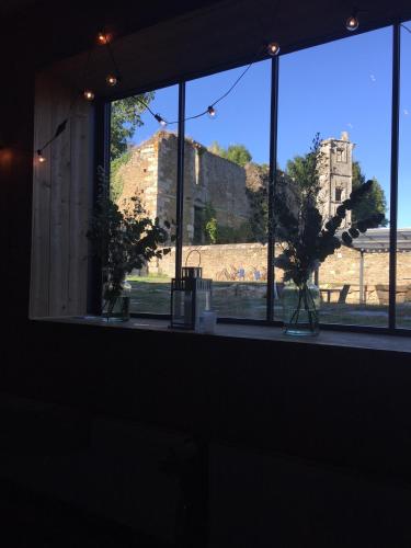 a window with a view of the ruins of a castle at Maison d'hôtes & Gîtes Domaine de la Garaye in Dinan