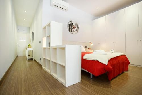 a white bedroom with a bed and a book shelf at PobleNou Loft Nº2 By MyRentalHost in Barcelona