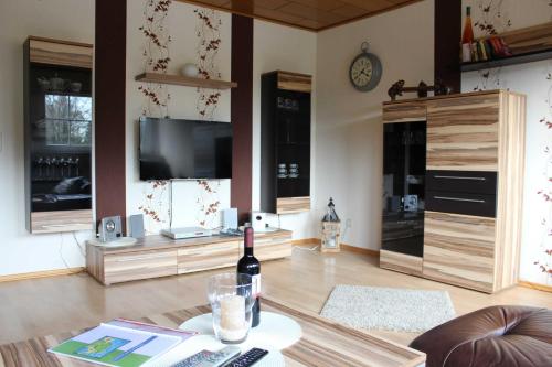 a living room with a bottle of wine on a table at Ferienwohnung Hooge Loogen, 35212 in Holtland