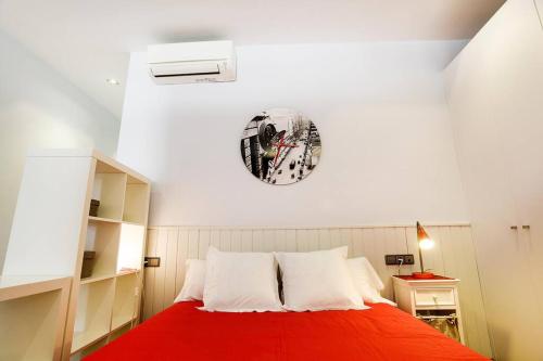 a bedroom with a red bed with a clock on the wall at Poblenou Loft Nº1 By MyRentalHost in Barcelona