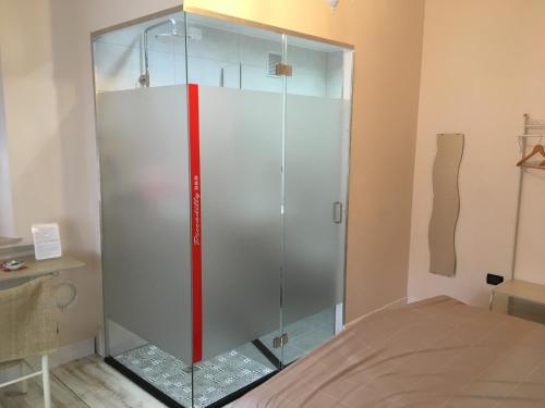 eine Glasduschkabine in einem Zimmer mit einem Bett in der Unterkunft piccadilly b&b in Pordenone