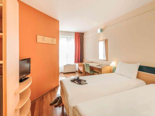 a hotel room with a bed and a television at ibis Bamberg Altstadt in Bamberg