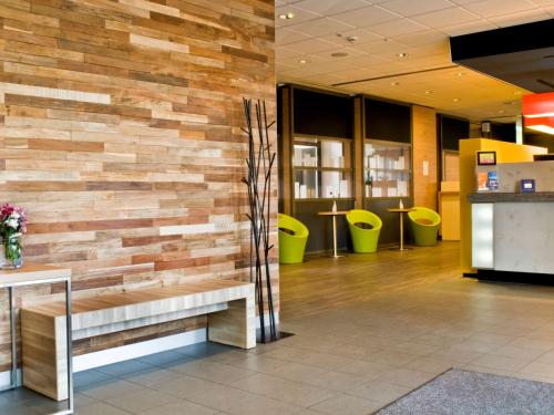 a wooden wall in a lobby with a bench at ibis Frankfurt Centrum in Frankfurt