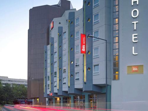 um edifício com um sinal vermelho na lateral em ibis Köln Centrum em Colônia