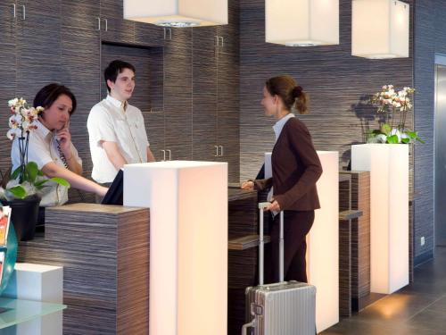 a group of people standing in an office with luggage at ibis Antwerpen Centrum in Antwerp