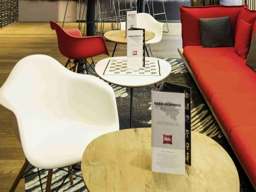 a living room with chairs and a couch and tables at Ibis Brussels City Centre in Brussels
