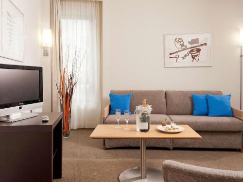 a living room with a couch and a table at Novotel Paris Rueil Malmaison in Rueil-Malmaison
