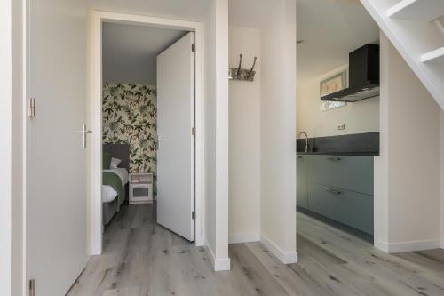 een hal met een slaapkamer met een bed en een deur bij Appartementen Parkzicht in Bergen aan Zee