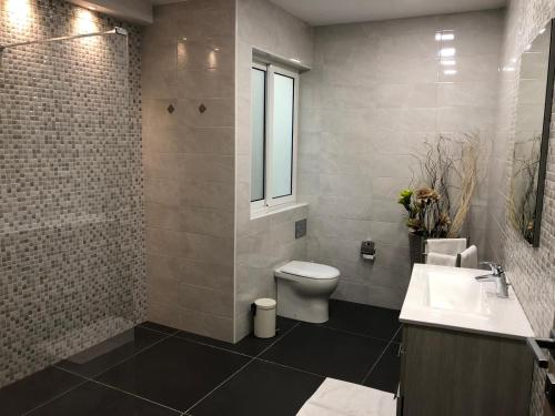 een badkamer met een toilet, een wastafel en een raam bij 189 Chezli Court in Birżebbuġa