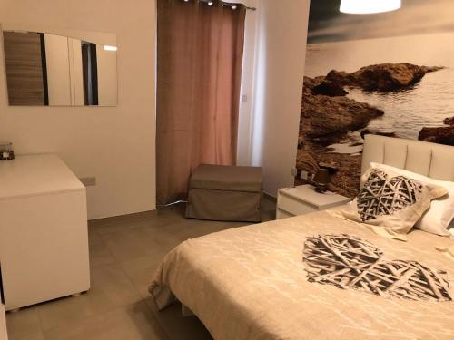 a bedroom with a bed and a painting on the wall at 189 Chezli Court in Birżebbuġa