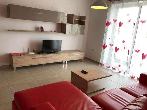 a living room with a couch and a flat screen tv at 189 Chezli Court in Birżebbuġa