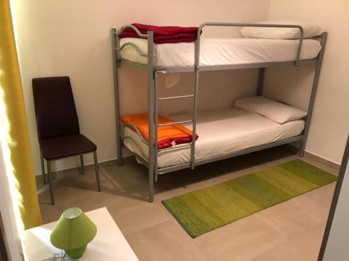 a room with two bunk beds and a chair at 189 Chezli Court in Birżebbuġa