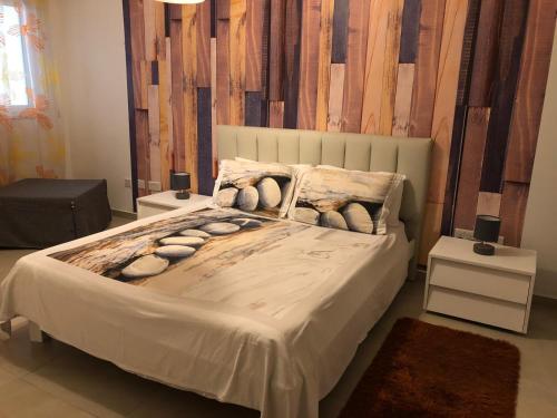 a bedroom with a large bed with two night stands at 189 Chezli Court in Birżebbuġa