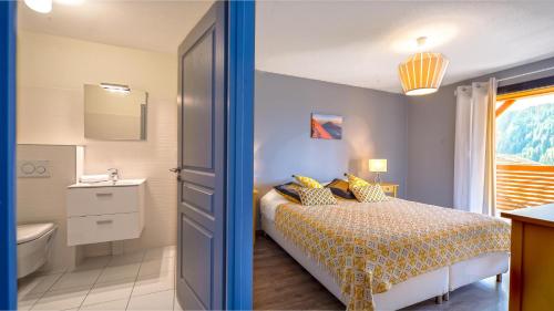 1 Schlafzimmer mit einem Bett und einem Bad in der Unterkunft Les 360 - Apt 14 - BO Immobilier in Châtel