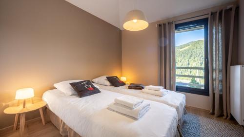 - 2 lits jumeaux dans une chambre avec une grande fenêtre dans l'établissement The View - Apt 12 - BO Immobilier - Châtel, à Châtel