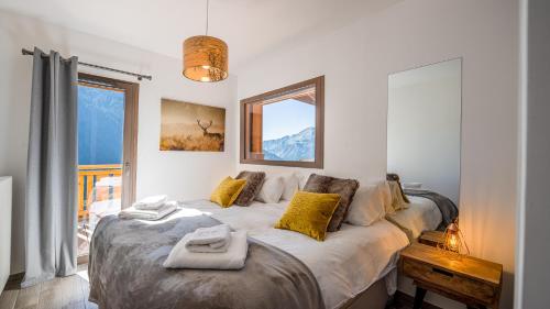 une chambre avec un grand lit avec des oreillers jaunes dans l'établissement L'O Rouge - Apt A203 - BO Immobilier - Châtel, à Châtel