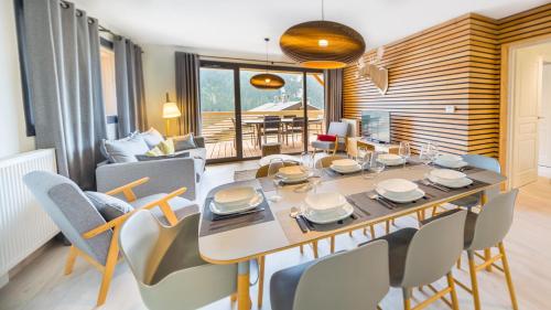 une salle à manger et un salon avec une table et des chaises dans l'établissement Les 360 - Apt 15 - BO Immobilier - Multipass 2025 offert, à Châtel