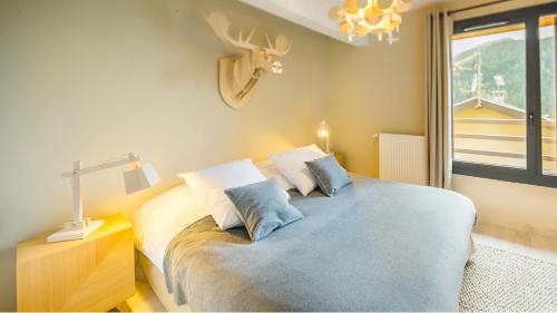 1 dormitorio con cama, lámpara y ventana en Les 360 - Apt 15 - BO Immobilier en Châtel