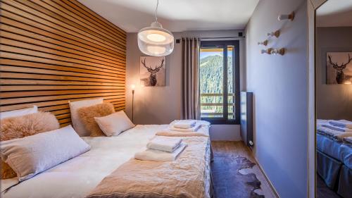 une chambre avec un lit avec deux oreillers dessus dans l'établissement The View - Apt 06 - BO Immobilier- Châtel - Châtel Multipass Été 2025 en option au tarif de 3euros par jour et par personne, à Châtel