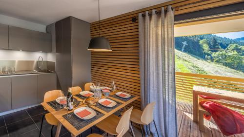 une salle à manger avec une table et une grande fenêtre dans l'établissement The View - Apt 06 - BO Immobilier- Châtel - Châtel Multipass Été 2025 en option au tarif de 3euros par jour et par personne, à Châtel