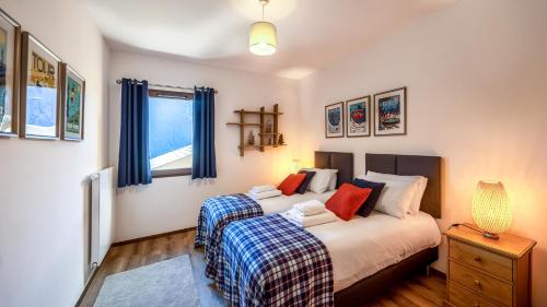 1 Schlafzimmer mit 2 Betten und blauen Vorhängen in der Unterkunft L'O Rouge - Apt A102 - BO Immobilier in Châtel