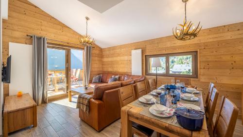 une salle à manger avec une table et un canapé dans l'établissement L'O Rouge - Apt A203 - BO Immobilier - Châtel, à Châtel