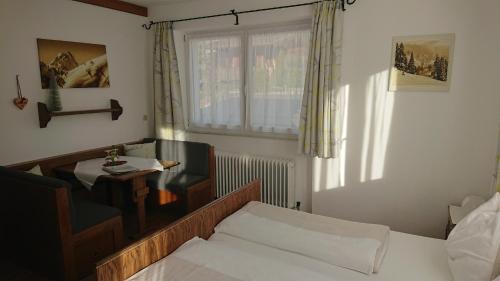 Haus Schiwelt في كيرشبرغ ان تيرول: غرفة نوم بسرير وطاولة ونافذة