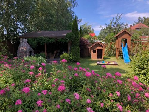 a garden with a gazebo and pink flowers at Willa Mare in Dębki