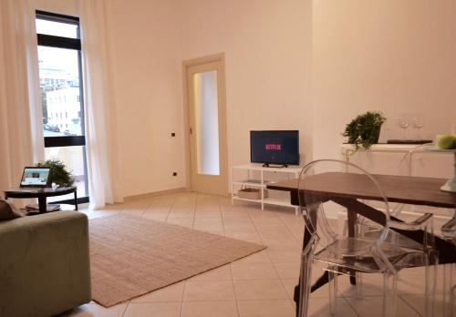 un soggiorno con tavolo in vetro e TV di Spacebility Expo a Cagliari