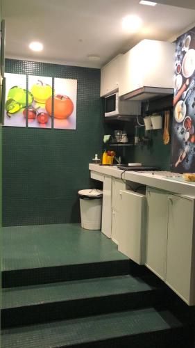 una cocina con armarios blancos y una pared verde en GLOBETROTTER HOSTEL, by Albany, en León