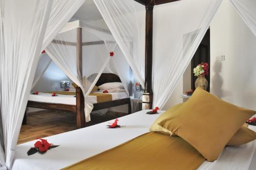 a bedroom with two beds with red flowers on them at Sea View Lodge Boutique Hotel in Jambiani