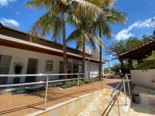 a house with palm trees in front of it at Villa de Holanda Parque Hotel in Holambra