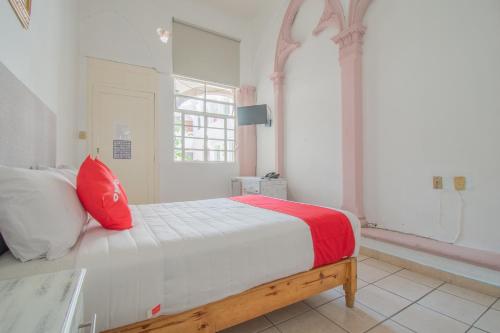 1 dormitorio con 1 cama con almohada roja en Hotel Imperial en Aguascalientes