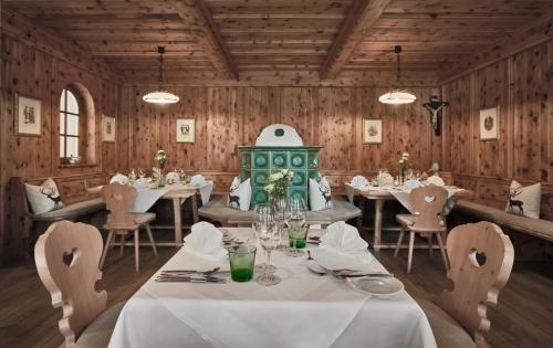 a dining room with tables and chairs and wooden walls at Lisi Family Hotel in Reith bei Kitzbühel