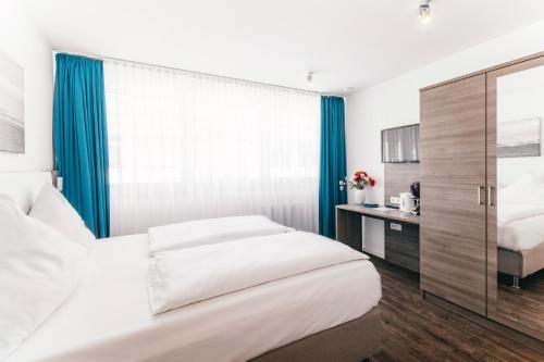a bedroom with two beds and a window at Haus am Dom - Apartments und Ferienwohnungen in Cologne