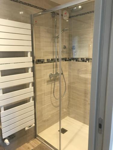 a shower with a glass door in a bathroom at Au coeur du Gévaudan appartement de plain pied in Marvejols