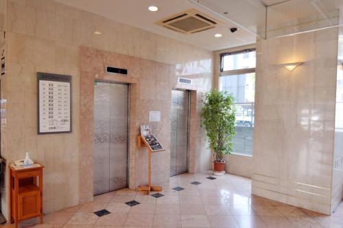 a lobby of a building with a potted plant at Kenchomae Green Hotel in Kumamoto