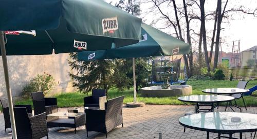 a patio with tables and chairs and an umbrella at Sosnowe Zacisze in Białystok