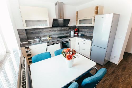 a kitchen with a table with blue chairs and a refrigerator at Haus am Dom - Apartments und Ferienwohnungen in Cologne