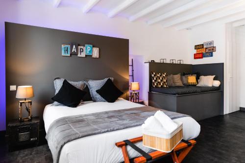 a bedroom with a large bed and a couch at La Maison Gustave in Narbonne