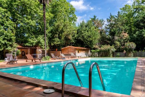 a swimming pool in a backyard with a patio and trees at Domaine du Mas Bazan in Alénya
