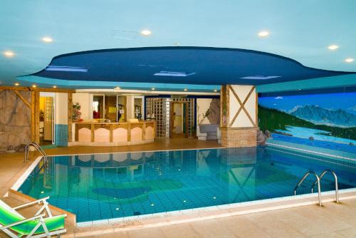 una grande piscina con soffitto blu di Hotel il Caminetto Sport a Canazei
