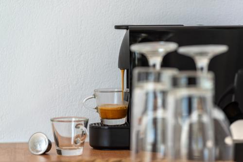 a coffee maker with two cups on a table at Adamant Suites in Fira