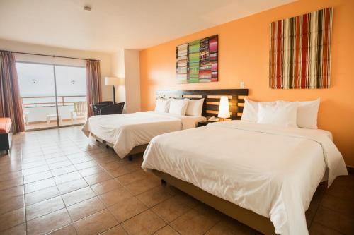 a hotel room with two beds and a balcony at Royal Decameron Mompiche - All Inclusive in Mompiche