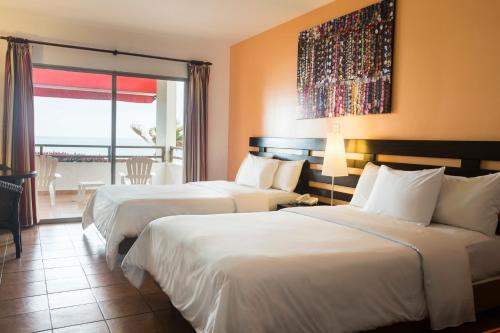 a hotel room with two beds and a balcony at Royal Decameron Mompiche - All Inclusive in Mompiche