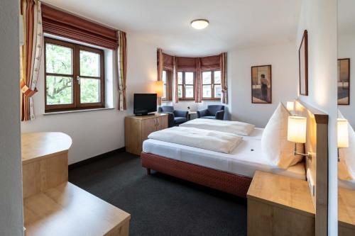 ein Hotelzimmer mit einem Bett und einem Wohnzimmer in der Unterkunft Alter Hof in Vaterstetten