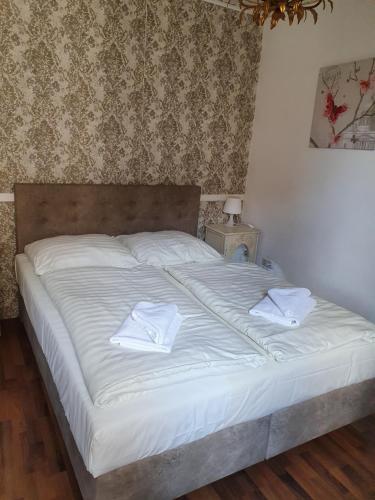 a white bed with two white towels on it at Pension Seibel in Munich
