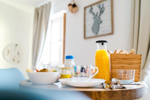 een tafel met een bord eten en een fles sinaasappelsap bij La Maison Gustave in Narbonne