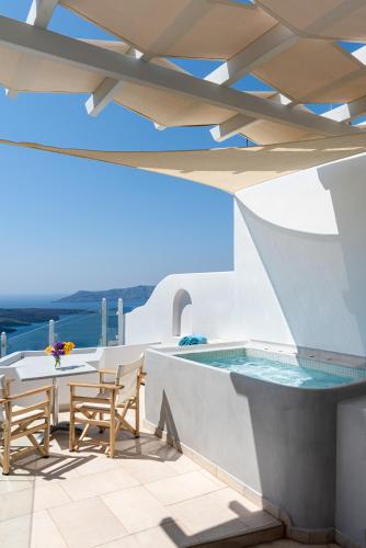 a pool on the roof of a house at Adamant Suites in Fira