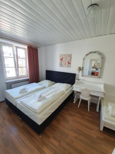 a bedroom with a bed and a desk and a mirror at Pension Seibel in Munich